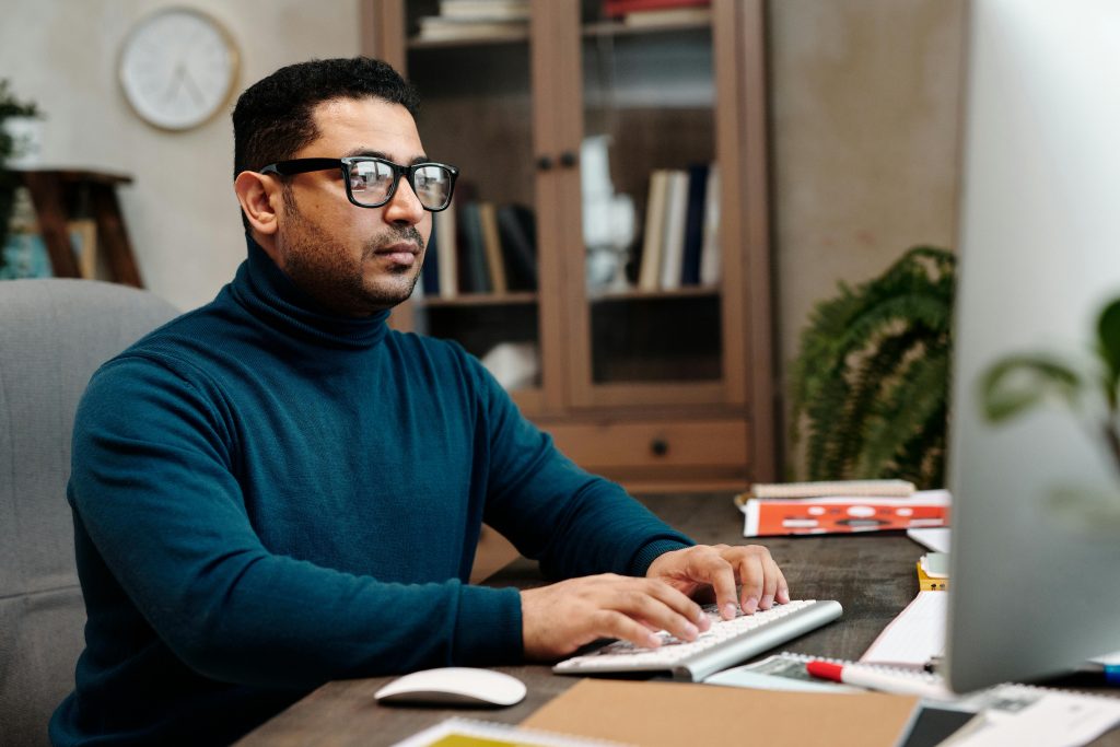 Professional man focused on his computer work in a modern office setting.